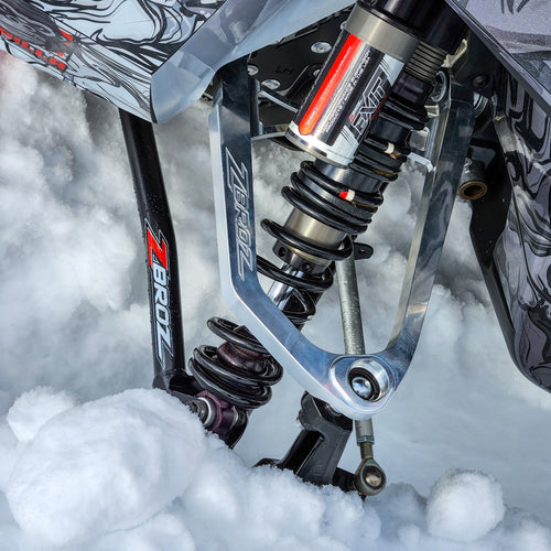 Close-up of Zbroz suspension on a snowmobile in a snowy environment.